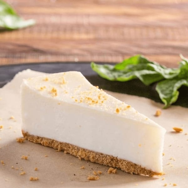 A slice of Ameci Pizza and Pasta Kitchen's cheesecake with a graham cracker crust and crumbs.